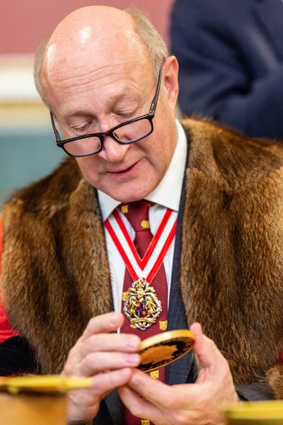 Second Warden Richard Fox examines a commemorative coin at the Trial of the Pyx 2019